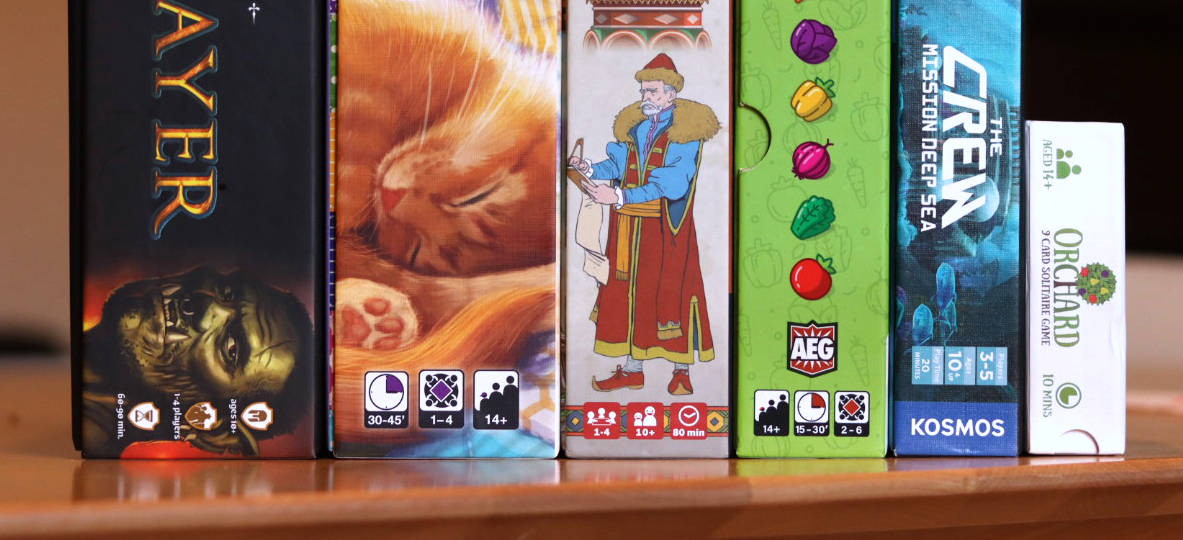 Row of board games displaying their player counts and estimated session lengths on their boxes